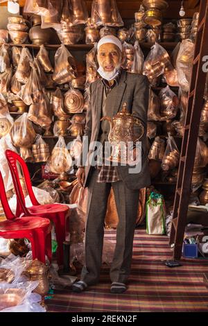 Sokalipura, Srinagar, Jammu and Kashmir, India. October 25, 2022. Man selling copper ware at a market in Srinagar. Stock Photo