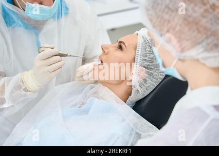 Young female patient at a doctors appointment in dental chair Stock Photo