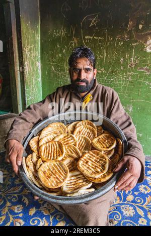 Raiyar Beruwa, Khansahib Tehsil, Jammu and Kashmir, India. October 31, 2022. A baker with freshly made flatbread. Stock Photo