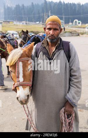 Khansahib Tehsil, Jammu and Kashmir, India. October 31, 2022. Man with a horse in Jammu and Kashmir. Stock Photo