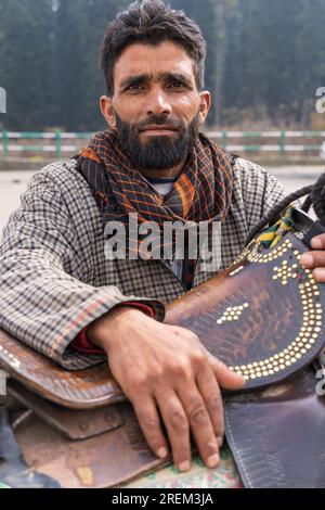 Khansahib Tehsil, Jammu and Kashmir, India. October 31, 2022. Man with a horse saddle in Jammu and Kashmir. Stock Photo