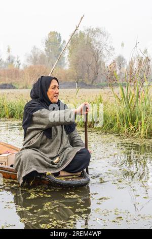 Rainawari, Srinagar, Jammu and Kashmir, India. November 2, 2022. Woman paddling a traditional boat on Dal Lake. Stock Photo