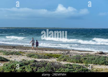 A couple walks along the beach on the East Coast of Bonaire, Caribbean Netherlands Stock Photo