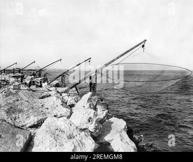 Chicago, Illinois:    September 5, 1929 Commercial fishermen's nets on the shore of Lake Michigan on the South Side of Chicago. The Adler Planetarium can be seen under construction at the far left shoreline. Stock Photo