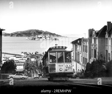 San Francisco, California:  c. 1955. The Hyde Street cable car climbs to the top of Russian Hill with Alcatraz Island in the background. Stock Photo