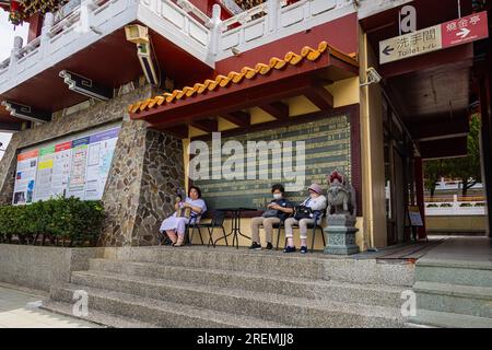 Sun Moon Lake, Taiwan - May 24, 2023: Three elder Ladys sitting on a bench at the Wenwu Temple. The temple offers grand architecture, vibrant colors, Stock Photo