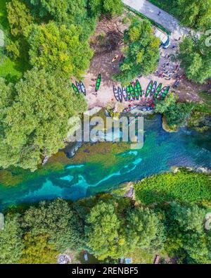 kayaks on the bank of the Tirino river, ready to welcome hiking tourists Stock Photo