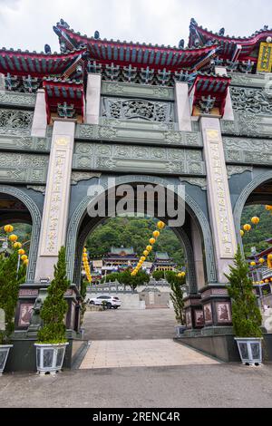 Puli, Taiwan - May 26, 2023: Baohu Temple of Dimu entrance gate majestic sight with rich red pillars, golden adornments, and detailed carvings, comple Stock Photo