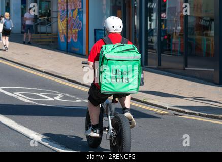 Uber Eats food delivery cyclist riding a bicycle in the city of Brighton & Hove, East Sussex, England, UK. Stock Photo