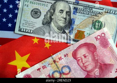 China. 29th July, 2023. In this photo illustration, a 100 RMB and a 100 USD currency cash are displayed on a table with the Chinese and American flags in the background. Credit: SOPA Images Limited/Alamy Live News Stock Photo