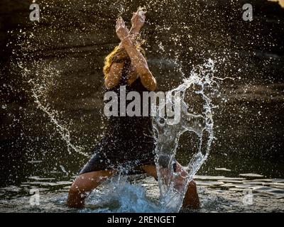 middle-aged woman dancing and throwing water in the air, Maioris beach, llucmajor, Majorca, Balearic Islands, Spain Stock Photo