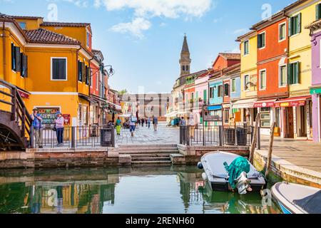 Colorful houses along the water canal with the leaning bell tower near the Church of Saint Martin Bishop in the island of Burano, Venice. Stock Photo