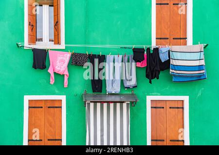 Tranquil scene with the colorful houses in Burano island, Venice. Clothes laundry left to dry Stock Photo