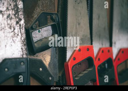 closeup old used rust hand saw sharp teeth for heavy duty wood cut home diy tool hang in workshop. Stock Photo