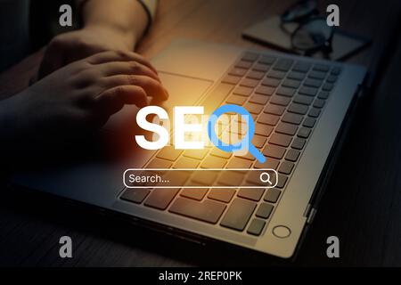 Woman using laptop with VR SEO text interface. SEO Search Engine Optimization concept. Ranking traffic on website. Digital marketing business. Stock Photo
