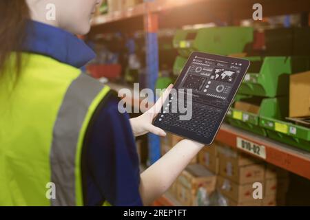 inventory manager worker using warehouse management system on tablet computer for tack checking products lots storage location Stock Photo