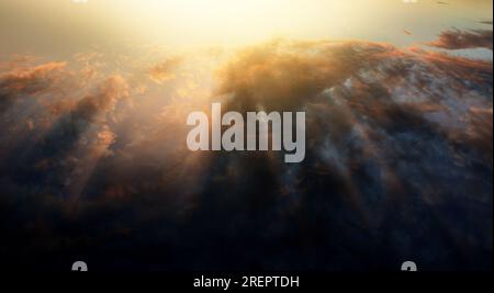 Flight above the clouds and the ocean at sunset. It can also be as sunrise. The sun coming over the horizon. Great contrast between light and dark Stock Photo