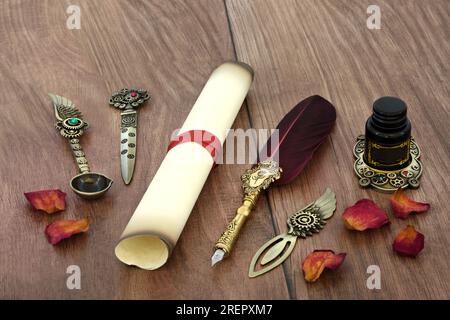 Parchment paper scroll with old feather quill pen, retro brass writing equipment and rose petals for love letter for Valentines Day on rustic wood. Stock Photo