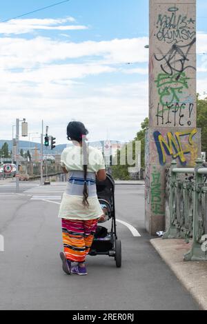 Vienna, Austria. 28 July 2023: A beautiful moment captured as a caring mother stands with her child at the zebra crossing, exemplifying love and prote Stock Photo