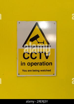 CCTV in operation sign against yellow background Stock Photo