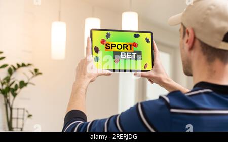 Man being happy winning a bet in online sport gambling application on his mobile phone Stock Photo