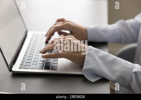 Hands of mature businesswoman typing on laptop keyboard Stock Photo