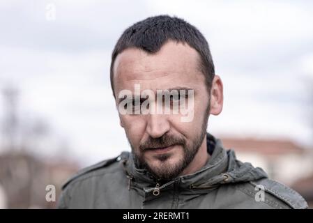 Portrait Of Young Handsome Caucasian Man with a stern or disappointed facial expression looking directly at the camera Stock Photo