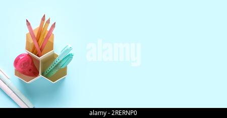 Stylish holder with school stationery on light blue background with space for text Stock Photo