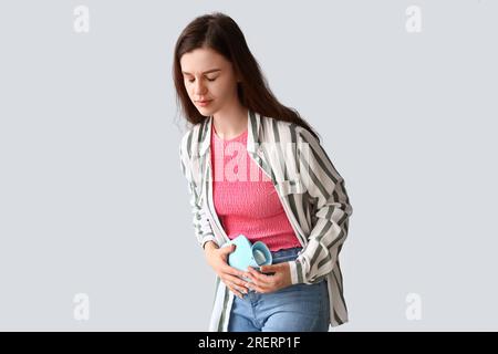 Young woman having menstrual cramps on light background Stock Photo
