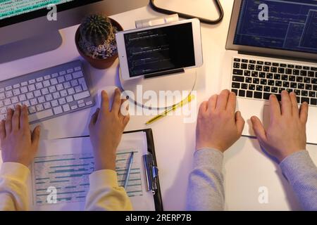 Programmers working in office at night, top view Stock Photo