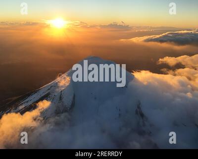 Magical sunrise over the snow-covered summit of Mt Taranaki in New Zealand's North Island Stock Photo
