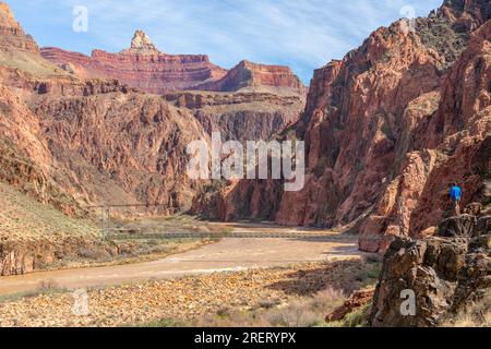 Lone hiker by the Colorado River on the Bright Angel Trail in the Grand Canyon. Stock Photo