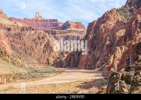 Lone hiker by the Colorado River on the Bright Angel Trail in the Grand Canyon. Stock Photo