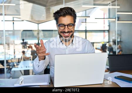 Happy young Latin business man working in office having conference call. Stock Photo