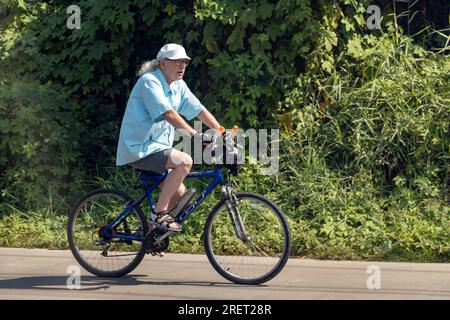 THAILAND, FEB 26 2023, An elderly man rides a bicycle in the Thai countryside Stock Photo