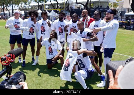 Teammates pose with Dallas Cowboys quarterback Dak Prescott, in red, as  they wear T-Shirts for his 30th birthday during the NFL football team's  training camp Saturday, July 29, 2023, in Oxnard, Calif. (