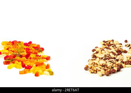 Comparison of unhealthy and healthy, gummy bears and various nuts, on white, copy room Stock Photo