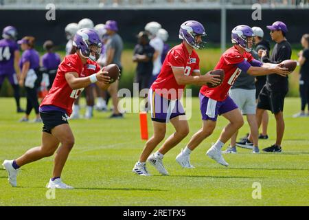 Minnesota Vikings quarterbacks Jaren Hall, Kirk Cousins, and Nick Mullens, left to right, run