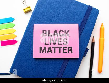 Protests broke out across the United States over the death of George Floyd. A man in a medical black mask and black glasses holds a white banner with Stock Photo