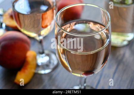 Glasses of peach wine on a dark wood table Stock Photo