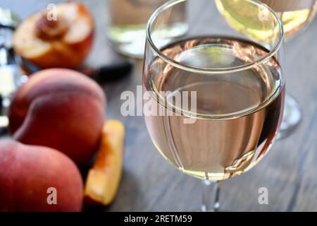 Glasses of peach wine on a dark wood table Stock Photo