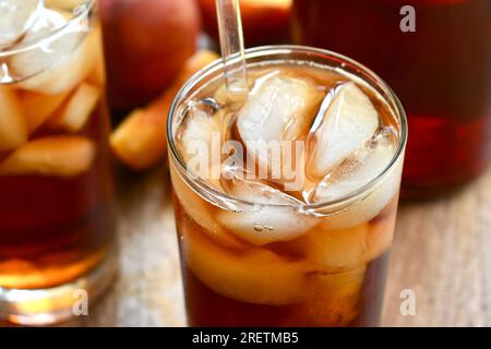 Two glasses of peach flavored iced tea on a wooden surface Stock Photo