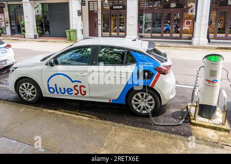A Blue SG electric car share vehicle plugged in to a charging station in Singapore Stock Photo