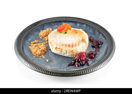 Appetizer of grilled soft camembert cheese served with cranberry jam and crumbs on plate Stock Photo