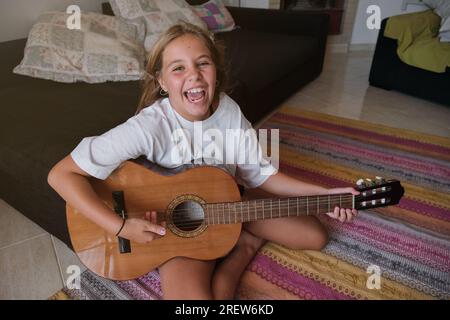 Blonde girl sitting on floor with penny board Stock Photo - Alamy