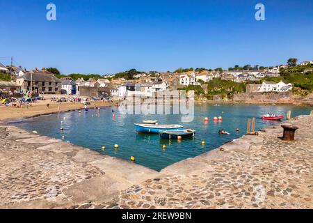 28 May 2023: Gorran Haven, Roseland Peninsula, Cornwall, UK - The inner harbour at Gorran Haven, with people, beach, boats,and harbourside buildings, Stock Photo