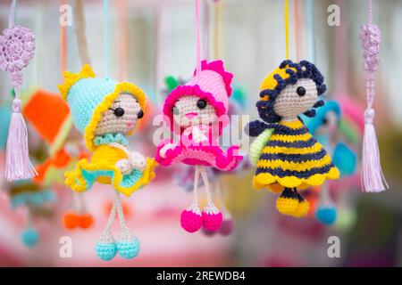 Small funny handmade knitted dolls are for sale at the craft fair. Stock Photo