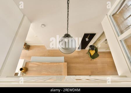 an overhead view of a room with wood flooring and light fixtures hanging from the ceiling over the dining area Stock Photo
