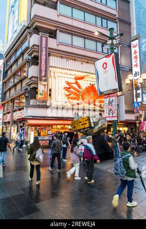 The popular Kani Doraku restaurant with its famous mechanical crab sign above the main entrance in the early evening at Dotonbori, Osaka. Stock Photo