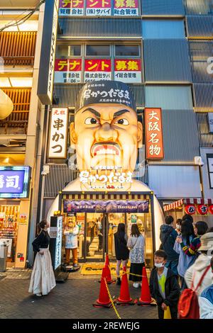 The famous Kushikatsu daruma restaurant facade in Dotonbori, Osaka, at night. Entrance with the 'angry chef' face sculpture illuminated above. Stock Photo